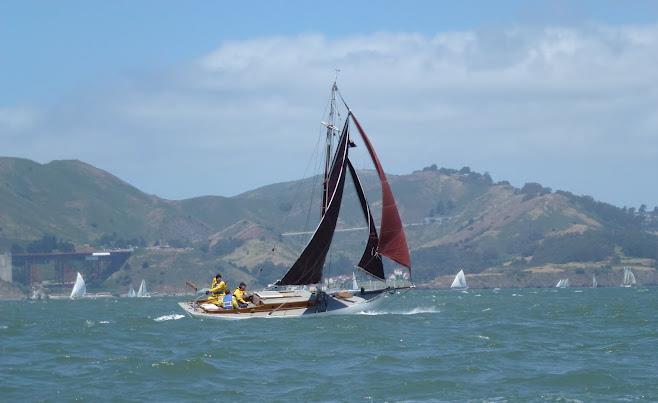 Gaff-rigged sloop Mercy blasting across the bay
